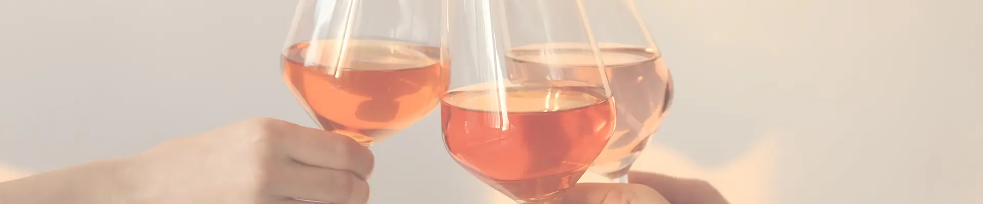 3 Gläser sind mit Orange Wein gefüllt und in der Mitte wird angestossen.