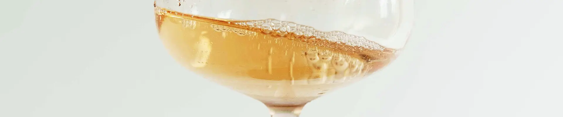 Ein schwingendes Weinglas mit Schaumwein gefüllt.