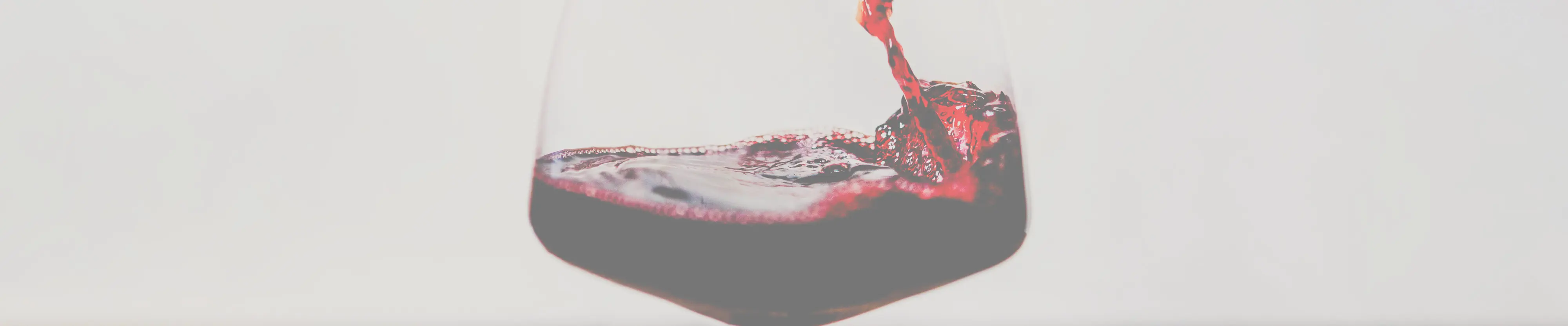 Ein schwingendes Weinglas mit Rotwein gefüllt.
