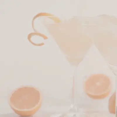 Ein Drink mit Orangenschale als Verzierung.