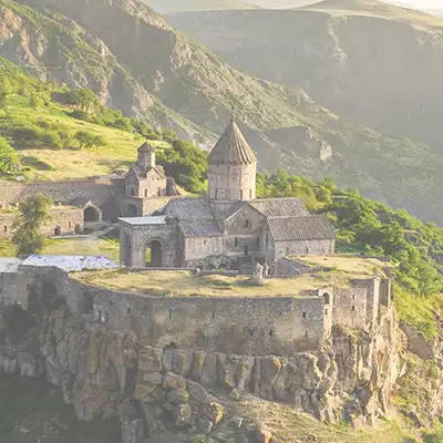 Landschaftsbild Armenien mit einer Steinklippe, worauf ein Steinhaus steht.