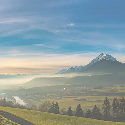 Landschaftsbild Österreich von einem Aussichtspunkt, von dem man den Himmel und die Berglandschaft in der Ferne sieht.